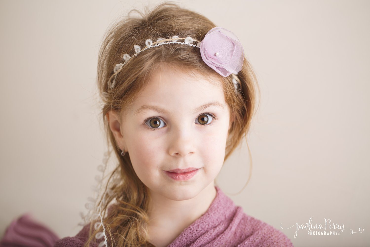 Close studio portrait of a girl with a lavender scarf and flower headband