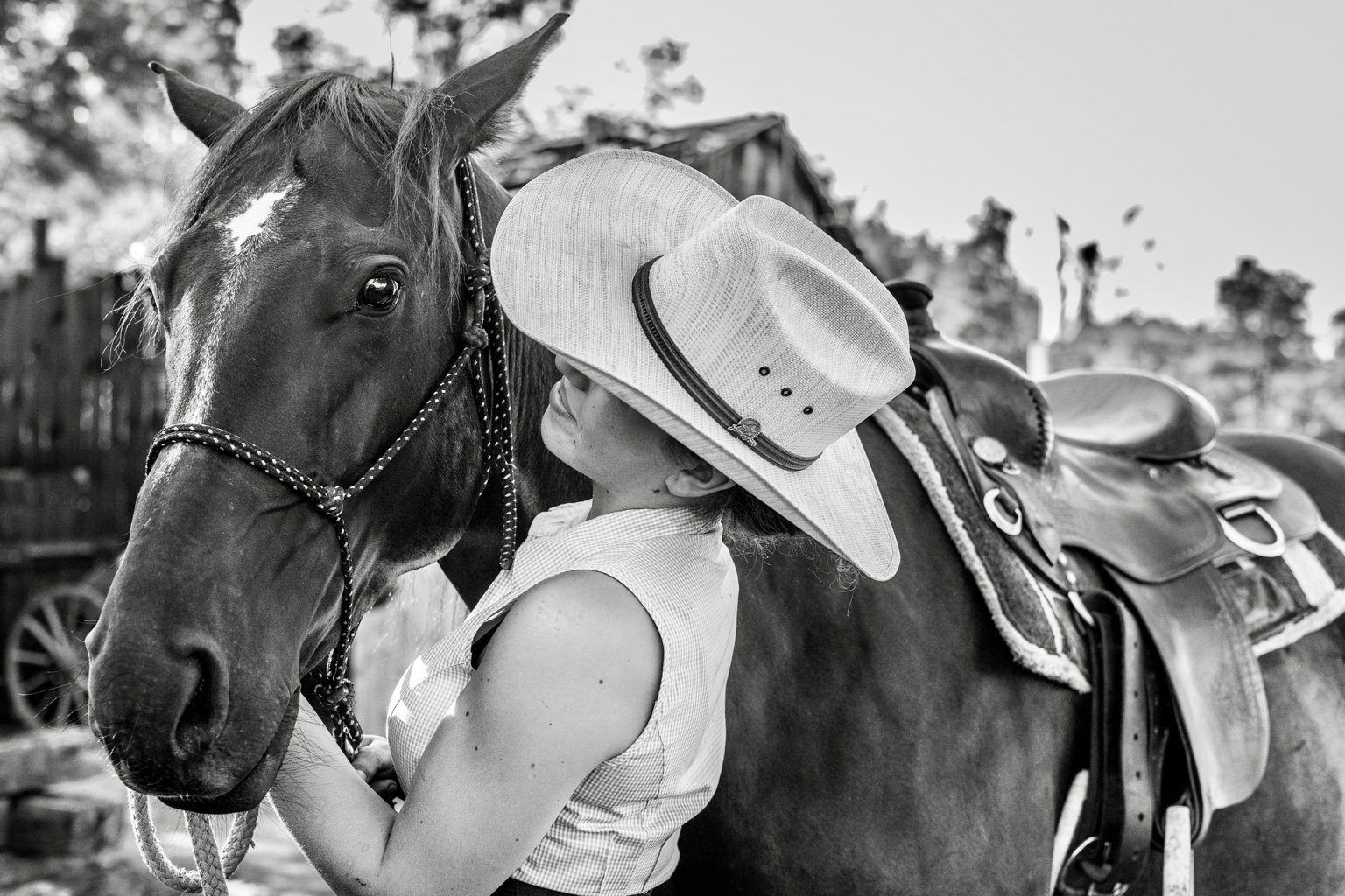 Black and white portrait of a woman embracing her horse