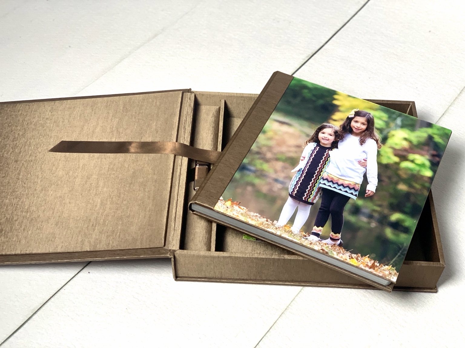 Portrait album with two girls on the cover in its fabric-covered presentation box