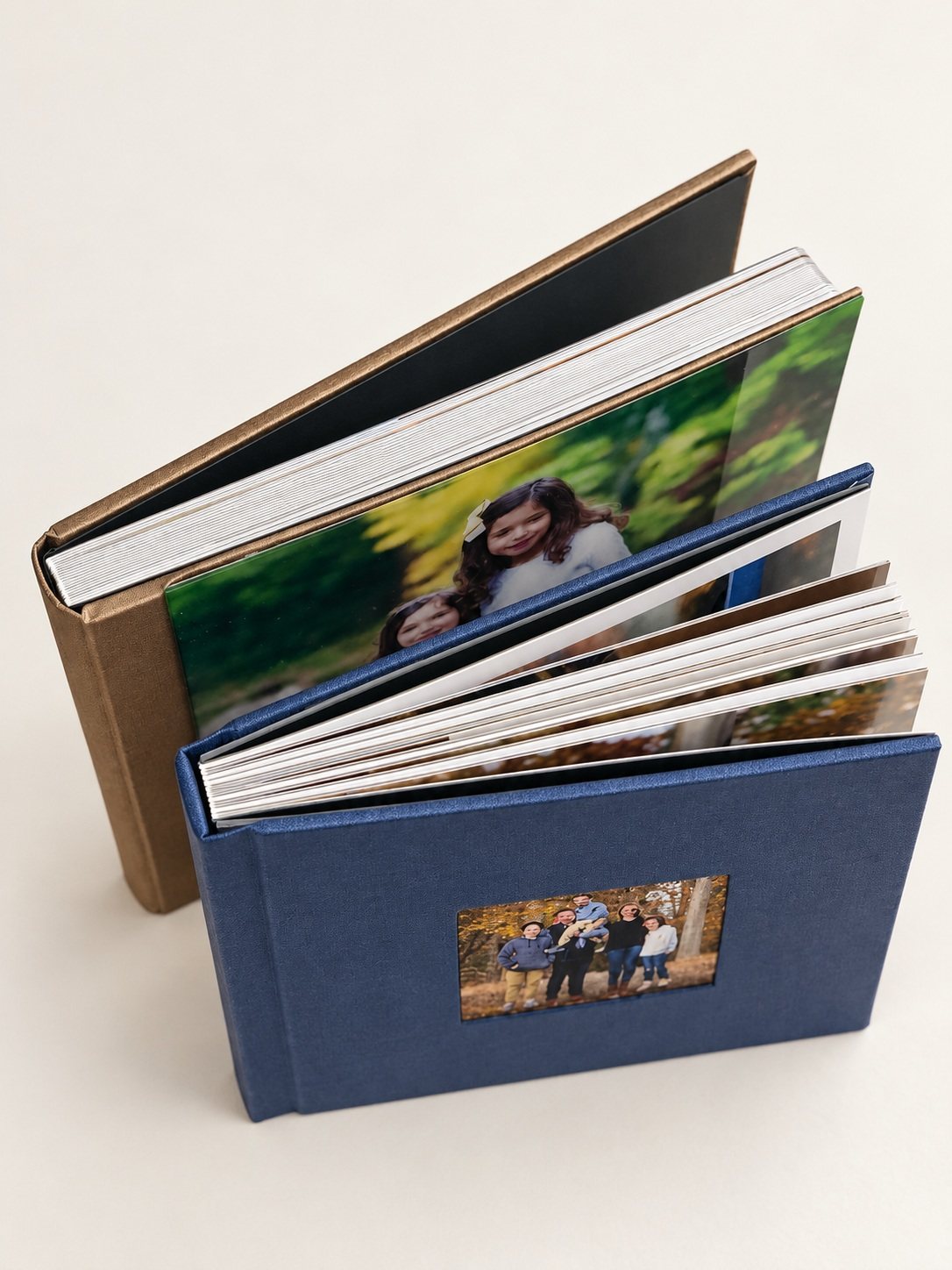 Brown and navy portrait albums showing their fabric covers and thick pages against a clean ivory background