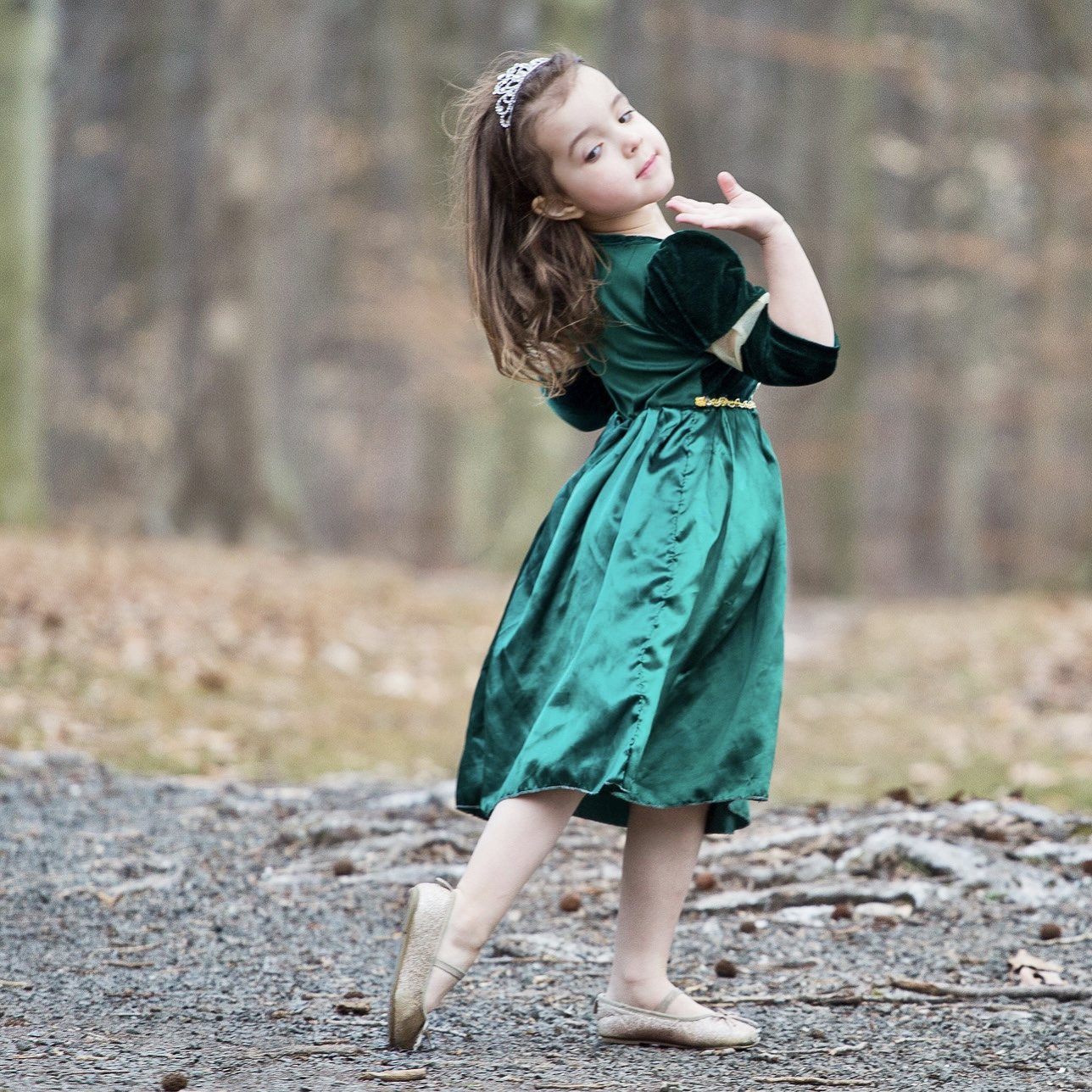 Girl in a green dress posing on a woodland path